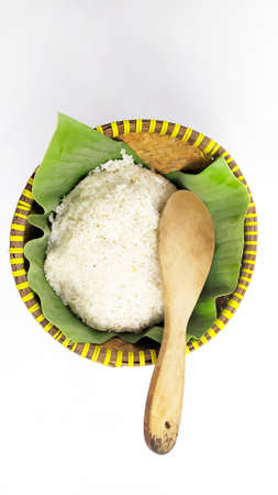 Nasi bakul or rice on Indonesian traditional rice basket from banana leaf and woven bamboo isolated on white backgroundの写真素材