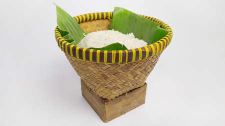 Nasi bakul or rice on Indonesian traditional rice basket from banana leaf and woven bamboo isolated on white backgroundの写真素材