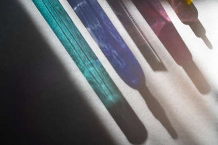 Blue turquoise pink and yellow glass bottle reflections in harsh light. Beauty products in a new light.の写真素材