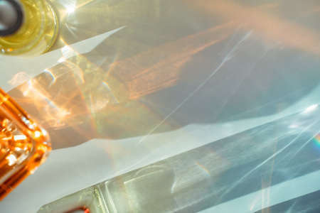 Face oil and perfume bottle reflections on white background. Yellow, orange, green and blue.の写真素材