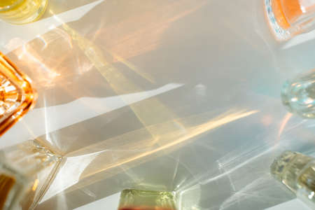 Face oil and perfume bottle reflections on white background. Yellow, orange, green and blue.の写真素材