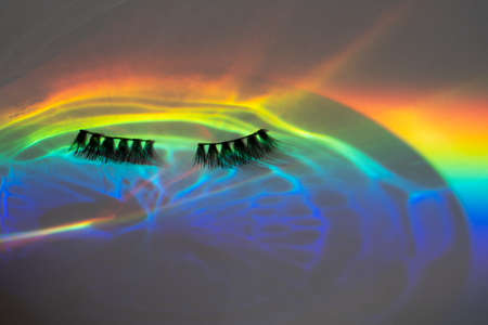 Fake eye lashes in a rainbow water reflection