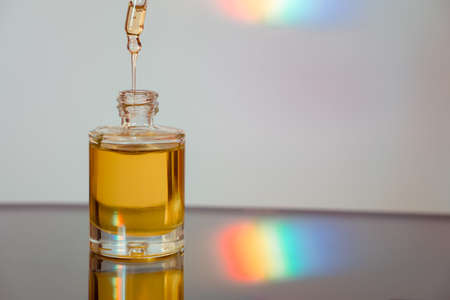 Face oil on reflective surface with a rainbow streak. Flowing serumの写真素材