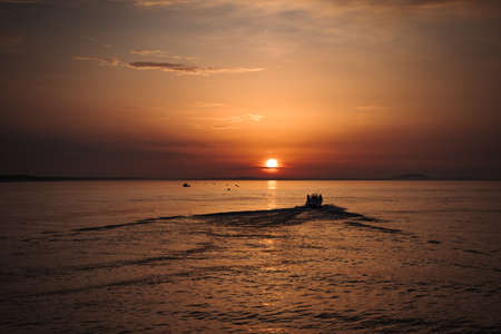 Sunrise on the medditerranean sea with a boat Valras France. Beautiful orange skyの写真素材