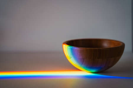 wooden bowl on gray background with rainbow light. Ecological and sustainable consumptionの写真素材