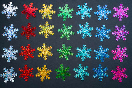 rainbow color glitter snowflakes on black paper background. LGBTQ inclusive winter holiday season marketing bannerの写真素材