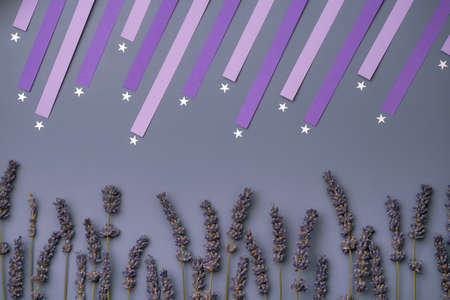 silver shooting stars confetti and dry lavender flower on violet background. Lavender field on a...
