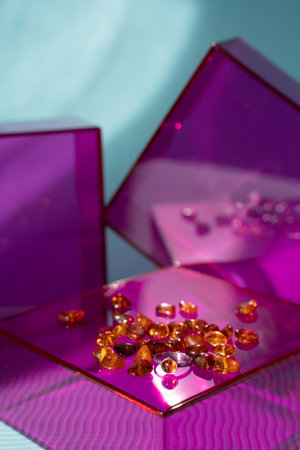 Amber ring and stones on pink glass podium and blue sunlit background. Modern gemstone presentation. November birthstoneの写真素材
