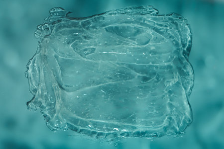 Dynamic clear gel swatch splash with air bubbles in water blue light. Hydrating face cream. Beauty...