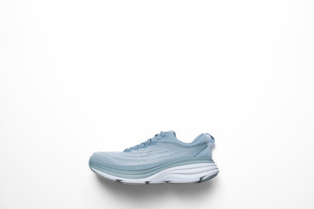 New light blue green female modern running shoe on white background. Stylish monochrome shoes for...