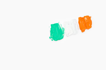 Green white and orange color paint splashes on white background. Irish flag design element for creative art and craft useの写真素材