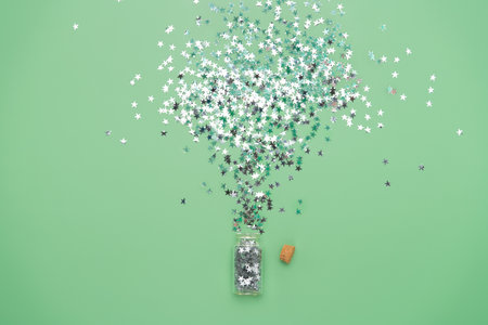 Glass phial with spilled magic silver stars. St Patrick's holiday background for greeting cards or party banner templatesの写真素材