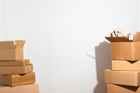 Creative minimalist image of stacked cardboard boxes on a plain background, representing concepts of...