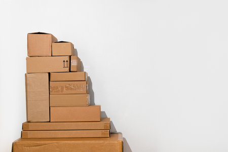 Creative minimalist image of stacked cardboard boxes on a plain background, representing concepts of...