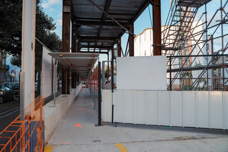 A minimalist urban scene showcasing a construction site with a towering crane. Highlights the intersection of infrastructure, development, and modern architecture under a clear sky.の写真素材