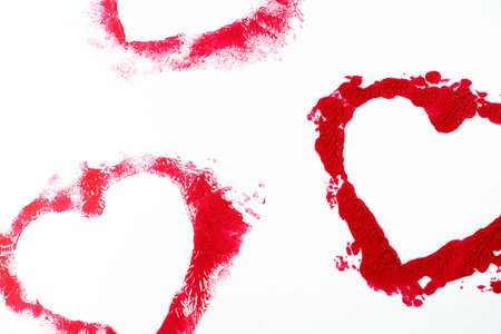 Isolated red lipstick smudge smear heart shaped. Cream makeup texture, cosmetics for Valentinesの写真素材