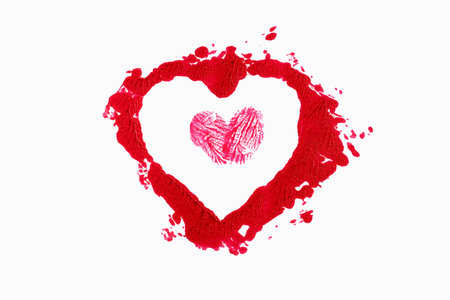 Isolated red lipstick smudge smear heart shaped. Cream makeup texture, cosmetics for Valentine'sの写真素材