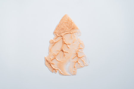Sparkly beige cream shaped like a Christmas tree on white background. Holiday body careの写真素材