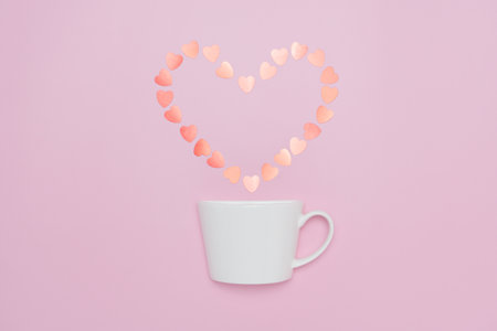 Creative minimalist composition of a white coffee cup releasing a heart-shaped arrangement of soft...