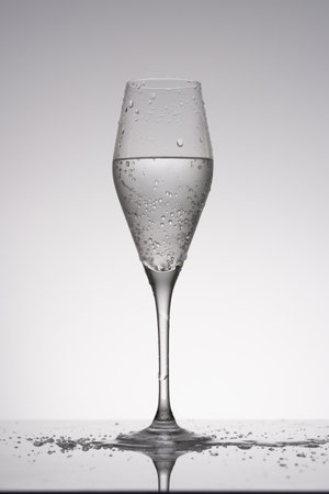 Wine glass with sparkling water, minimalist backlit photoの写真素材