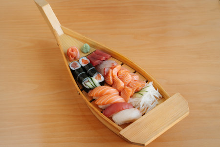 Sushi sashimi and onigiri boat. Delicious freshly prepared meal, perfect for menus, restaurants, or food delivery concepts.の写真素材