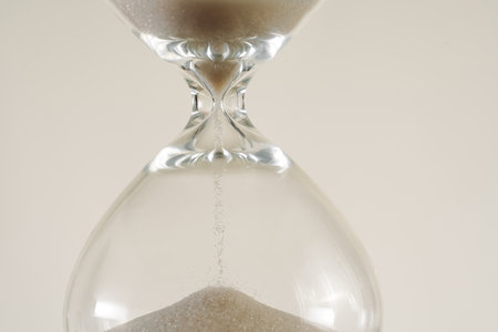 A minimalist conceptual image of an hourglass to symbolize the passage of time, aging, and...