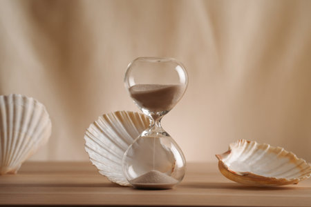 A sophisticated display featuring a delicate hourglass surrounded by elegant seashells, emphasizing...