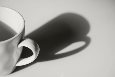 Coffee cup with long shadow side view. Focus on cup. Morning energy color cloud whiteの写真素材