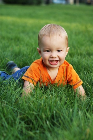 Happy baby is playing on the grassの写真素材