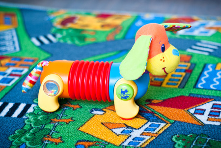 Toy funny dog on the colored matの写真素材