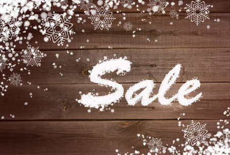 Winter sale background with snow and snowflakes on wooden surfaceの写真素材