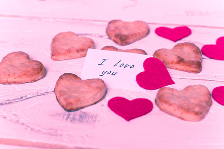 Cookies in the shape of hearts and red decorative hearts. Image tinting. Selective focusの写真素材