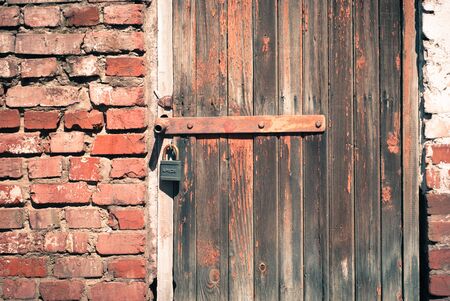 old shabby wooden door with a padlockの写真素材