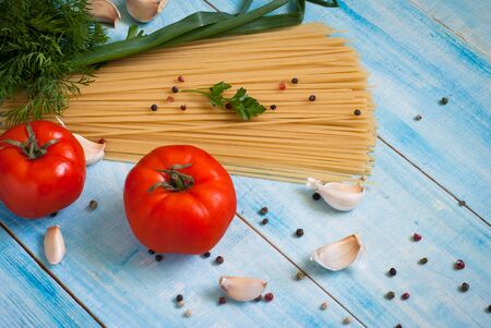 Uncooked spaghetti on a blue wooden table. Selective focus.の写真素材