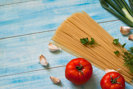 Uncooked spaghetti on a blue wooden table. Selective focus.の写真素材