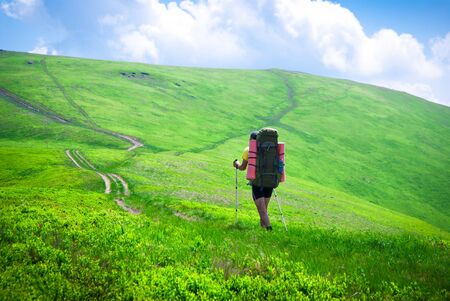 Hiking in the mountains. Hiker goes on the trail in the mountainsの写真素材