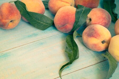 Few ripe peaches on a wooden table. Image tinted