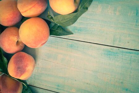 Few ripe peaches on a wooden table. Image tintedの写真素材
