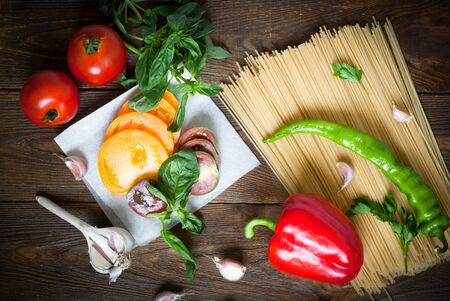 Ingredients for cooking pasta - spaghetti, tomatoes, peppers, garlic and basilの写真素材