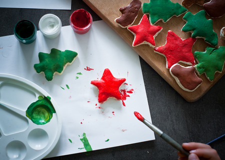 A child paints the colors of Christmas toys made of dough.の写真素材