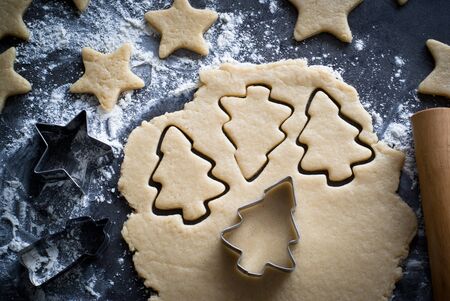 Baking Christmas cookies -  dough on the table, cookie cutters and cookies.