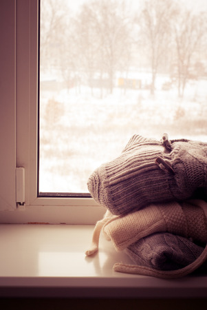 Pile of knitted winter clothes on the windowsill.の写真素材