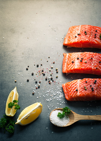 Raw Fillet of salmon with sea salt and pepper. Fresh fish. Top view, copy space.の写真素材