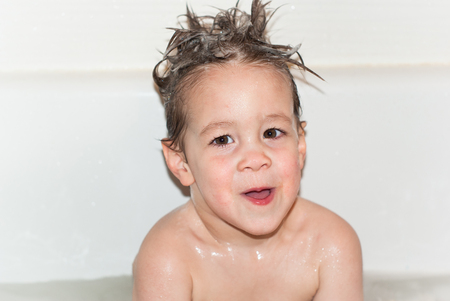 Adorable little boy bathes in a bathroom.の写真素材