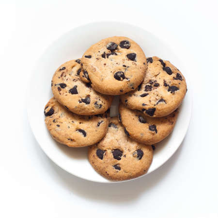 Chocolate chip cookies at the plate isolated on white.