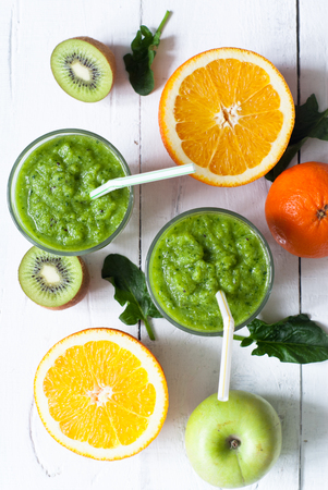 Fresh green smoothie from spinach, apple, kiwi and orange. Healthy drink.の写真素材