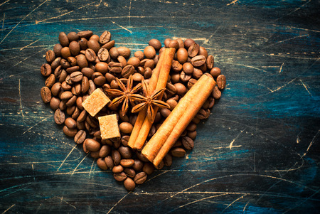 Background with coffe and spices in the shape of heart at dark surface. Image toned, space for text.の写真素材