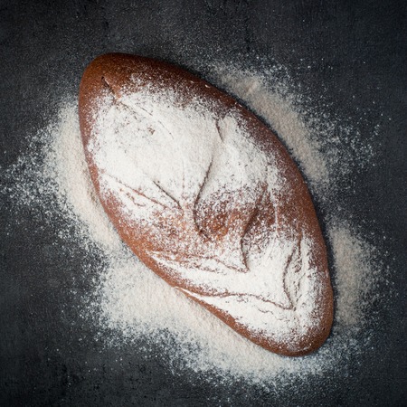 Homemade whole grain bread on a dark background.