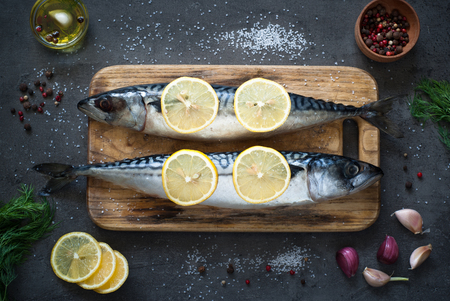 Fresh fish. Raw mackerel with salt, lemon and spices on a dark background.の写真素材