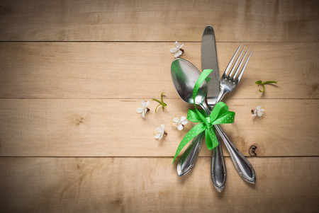 Spring table setting with  cutlery and flowers. Silverware in spring scenery.